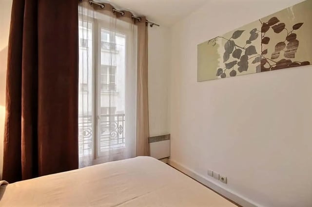 Bed with dark curtains and painting Bedroom at Apartment in Rue Claude Terrasse, 75016 Paris, France in Paris Student Accommodation