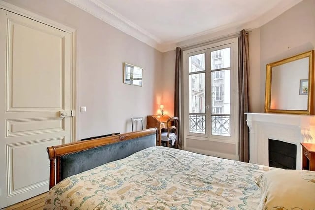 Bed fireplace mirror desk window bedroom at Apartment in Rue Damrémont, 75018 Paris, France in Paris Student Accommodation