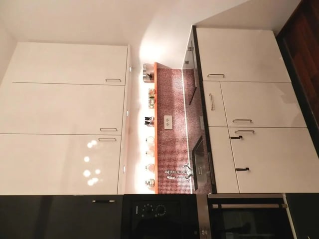 Modern white cabinets with red tiled backsplash Kitchen at Studio in Rue Dauphine, 75006 Paris, France in Paris Student Accommodation