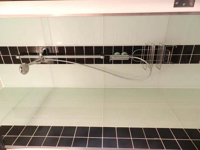 Chrome showerhead hose rack tiled bathroom interior at Studio in Rue Dauphine, 75006 Paris, France in Paris Student Accommodation