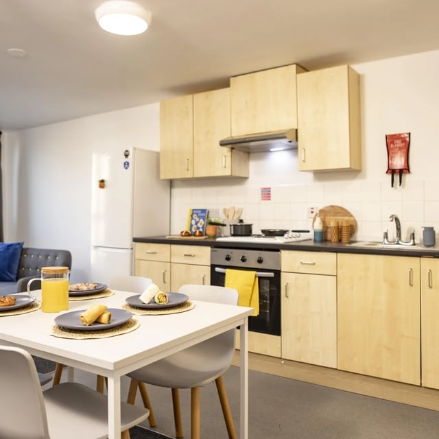 Dining table with food and chairs kitchen living room at Albert Court in Liverpool Student Accommodation