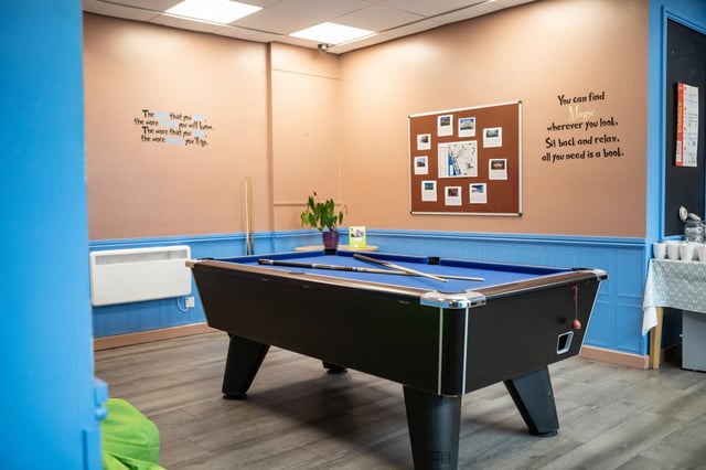 Pool table with cues plant and bulletin board playing area at Albert Court in Liverpool Student Accommodation
