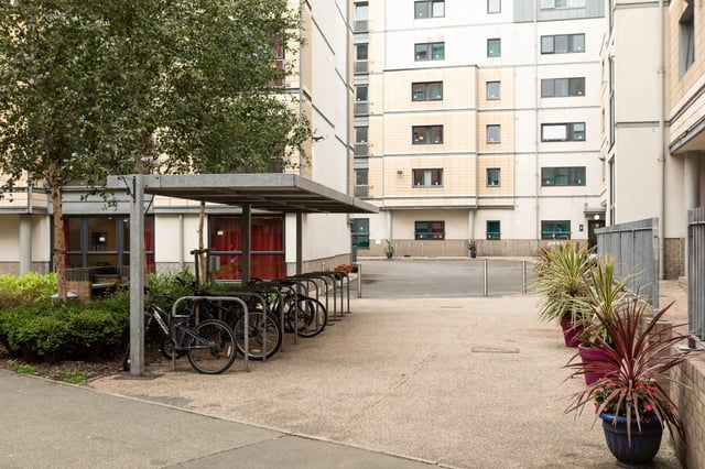 Bicycles under shelter with potted plants exterior at Albert Court in Liverpool Student Accommodation