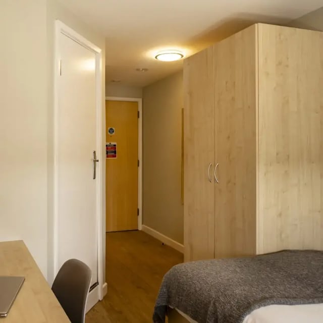 Wardrobe and desk with laptop bedroom at Belgrave View in Birmingham Student Accommodation