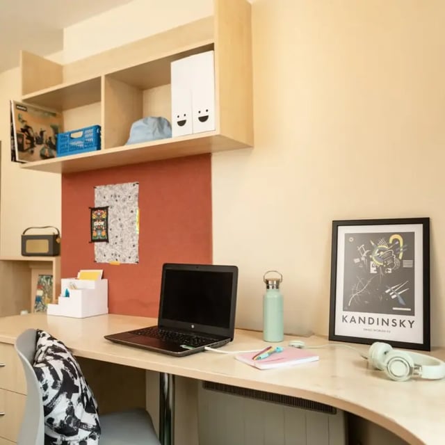 Desk with laptop water bottle artwork study area at Belgrave View in Birmingham Student Accommodation
