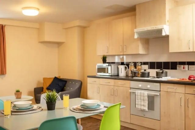 Table chairs microwave cabinets oven kitchen and living room at Belgrave View in Birmingham Student Accommodation