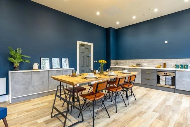 Dining table with chairs and kitchen area. at Chamberlain Place in Birmingham Student Accommodation