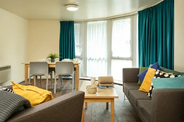 Sofa with cushions dining table chairs living area at Burley Road in Leeds Student Accommodation