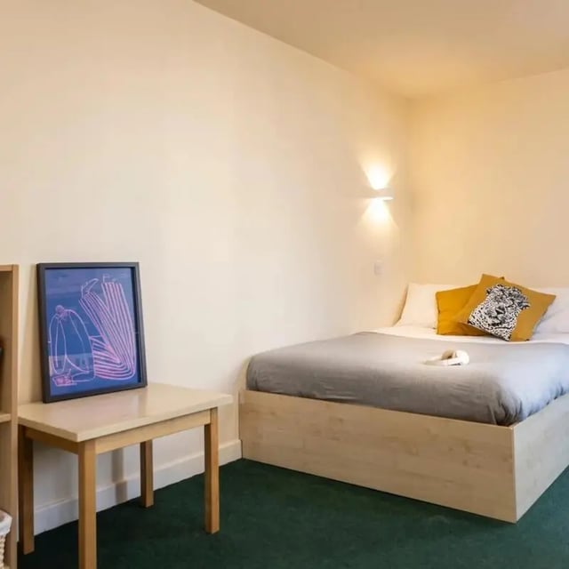 Framed artwork on table and bed bedroom at Burley Road in Leeds Student Accommodation