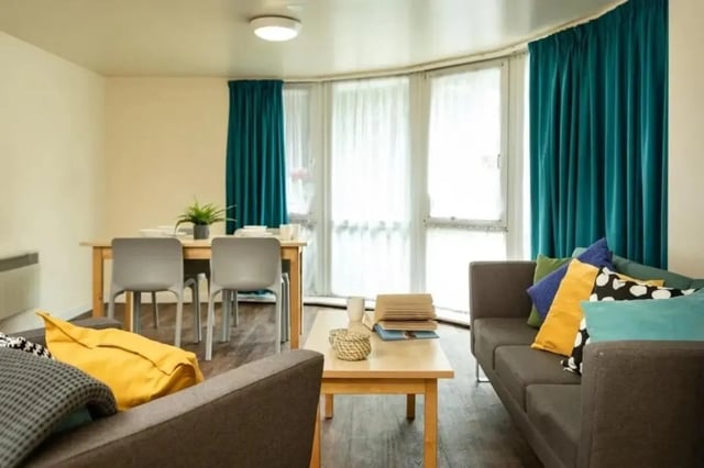Sofa dining table chairs with pillows living room at Burley Road in Leeds Student Accommodation