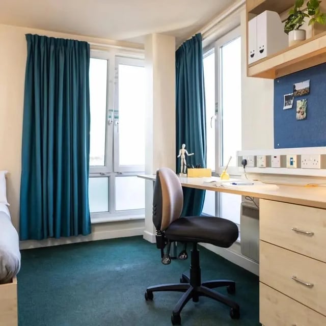 Desk chair, desk, and windows Student bedroom at Burley Road in Leeds Student Accommodation