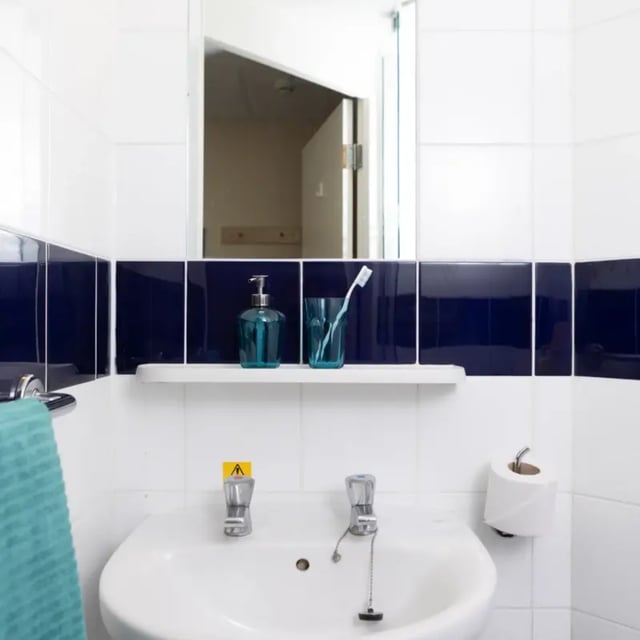Sink soap dispenser toothbrush and toilet roll bathroom at Mcmillan student Village in Greenwich Student Accommodation