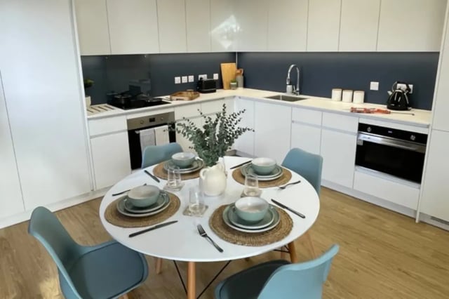 Dining table with place settings and kitchen area. at Mcmillan student Village in Greenwich Student Accommodation