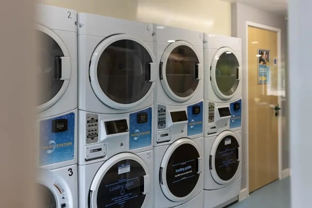 Stacking washing machines and dryers with control panels laundry room at Bonington Student Village in Loughborough Student Accommodation