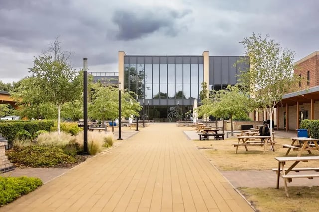 Picnic tables with trees and modern building exterior at Bonington Student Village in Loughborough Student Accommodation