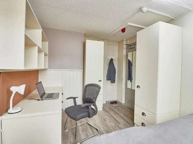 Desk laptop lamp chair wardrobe interior bedroom at Meadow Court in Edinburgh Student Accommodation
