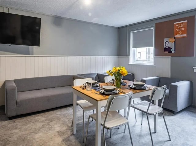 Sofa dining table chairs and flowers living room at Meadow Court in Edinburgh Student Accommodation