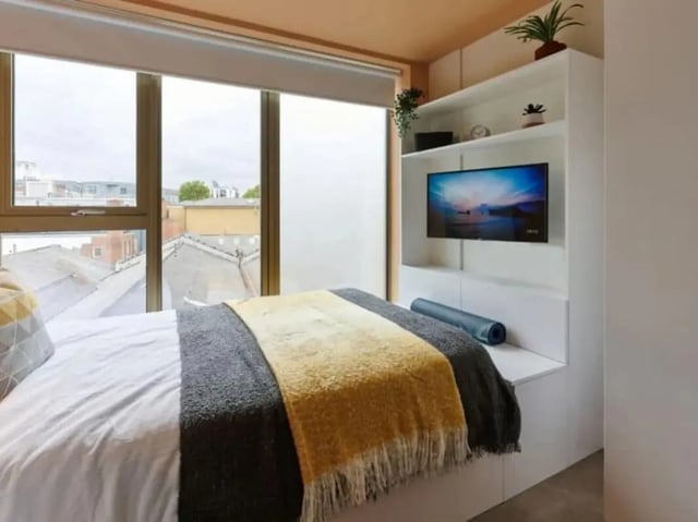 Bed with blankets TV on shelf bedroom at View Studios in London Student Accommodation