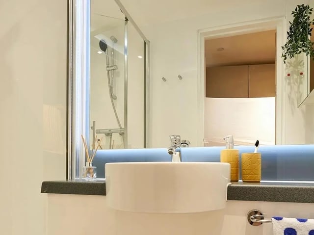 White sink shower and soap dispenser bathroom at View Studios in London Student Accommodation