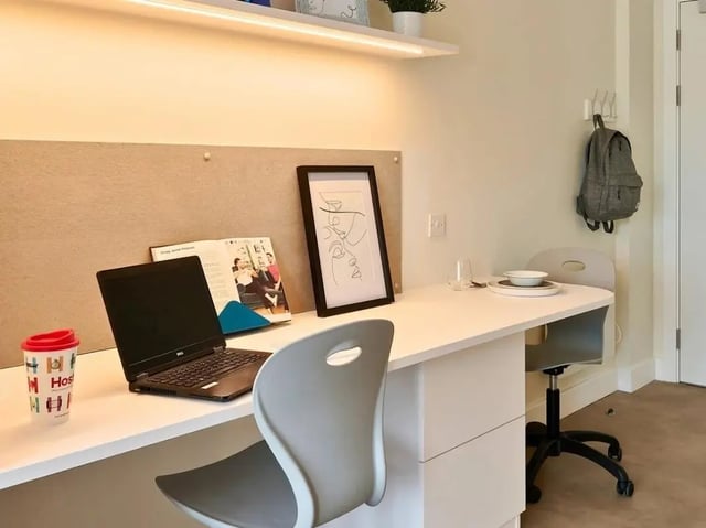 Laptop cup book framed art backpack study area at View Studios in London Student Accommodation