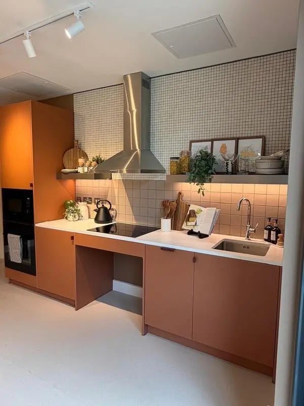 Modern kitchen with orange cabinets hob and sink Kitchen at Valerian in York Student Accommodation