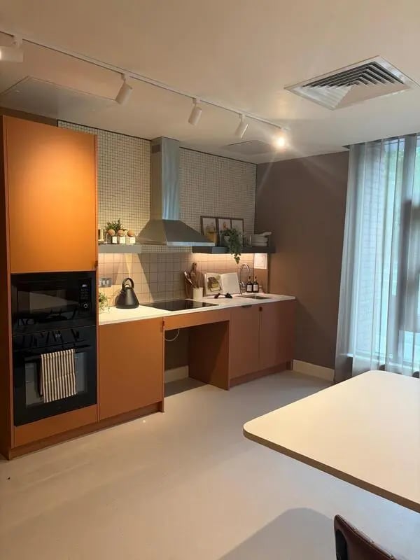 Modern kitchen with orange cabinets and oven at Valerian in York Student Accommodation
