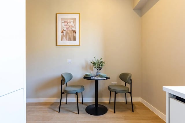 Two chairs small table and framed art dining area at Fitz and Knox in Cardiff Student Accommodation