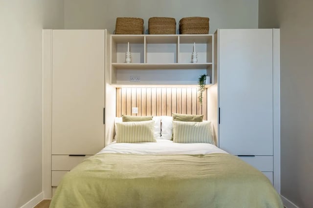 Bed with green blanket and striped pillows bedroom at Fitz and Knox in Cardiff Student Accommodation