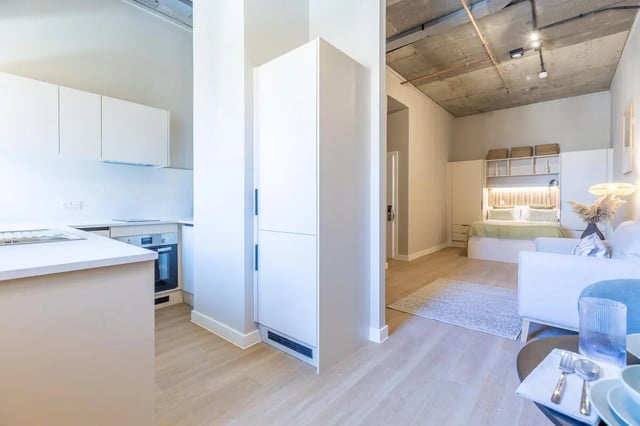 White kitchen with bed and sofa living room at Fitz and Knox in Cardiff Student Accommodation