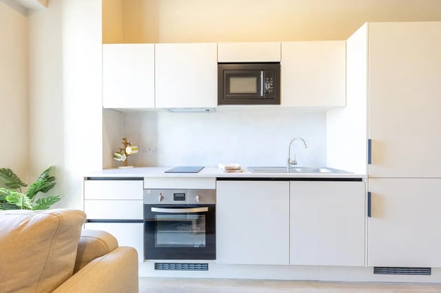 White cabinets microwave oven and sink kitchen at Fitz and Knox in Cardiff Student Accommodation