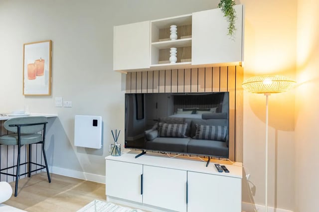 Modern living room with TV, sofa, and shelf Image Type: Living Room at Fitz and Knox in Cardiff Student Accommodation