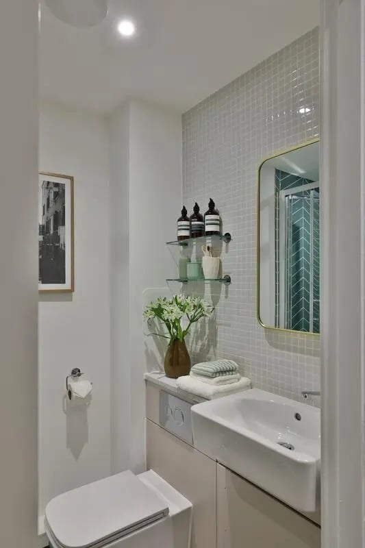 Toilet sink shelves with bottles and flowers bathroom at London Road Apartments in Southampton Student Accommodation