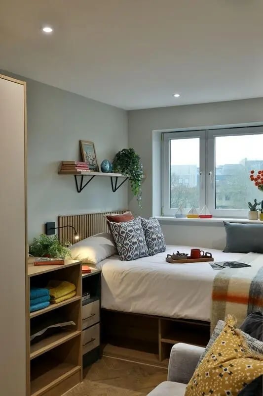 Bed with pillows shelves and window bedroom at London Road Apartments in Southampton Student Accommodation