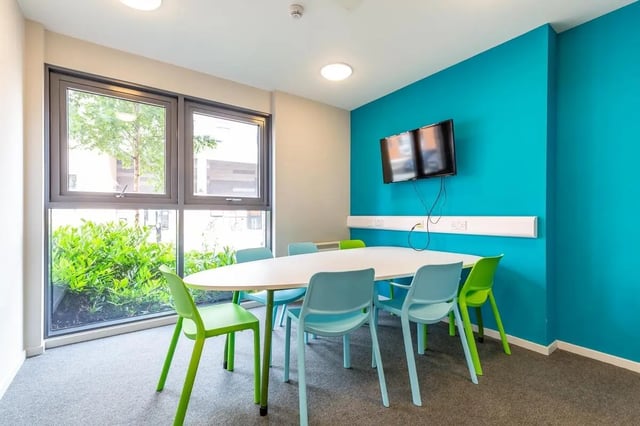 Oval table with colorful chairs mounted TV Study area at Rosedale Court in Newcastle Upon Tyne Student Accommodation