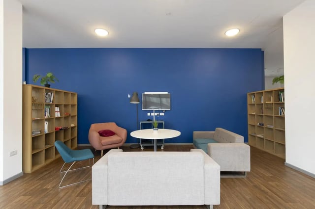Sofa chairs bookshelf tv table living room at Newton Court in Newcastle Upon Tyne Student Accommodation
