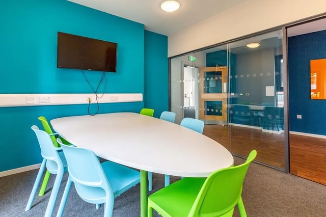 White table bright chairs wall mounted television communal area at Marshall Court in Newcastle Upon Tyne Student Accommodation
