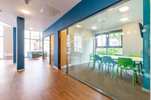 Glass meeting room with table chairs and blue wall common room at Marshall Court in Newcastle Upon Tyne Student Accommodation