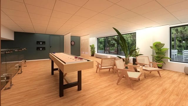 Shuffleboard table lounge chairs dartboard game room at St James Glasgow in Glasgow Student Accommodation