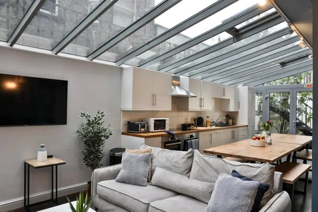 Sofa kitchen table TV and plant living room at Francis Gardner in London Student Accommodation
