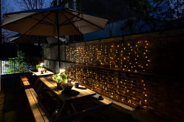 Picnic tables umbrellas string lights outdoor seating area at Francis Gardner in London Student Accommodation