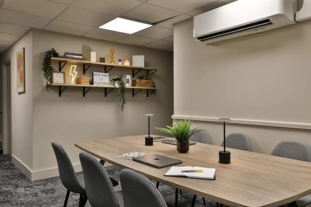 Table with chairs laptops and plant communal space at Francis Gardner in London Student Accommodation