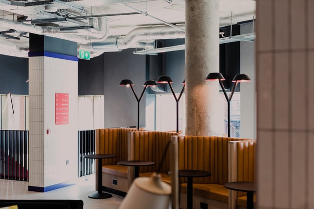 Tan booths with tables and lamps communal area at Vita Student Bruce Street in Belfast Student Accommodation