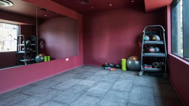 Gym equipment with mirror and burgundy walls gym area at Press House in London Student Accommodation