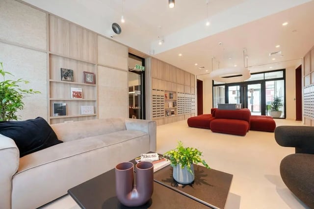 Sofa, shelves, red ottomans, contemporary lounge area at Press House in London Student Accommodation