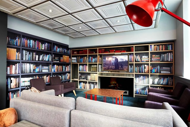 Bookshelves couches and coffee table living room at Vita Student Zed Alley in Bristol Student Accommodation
