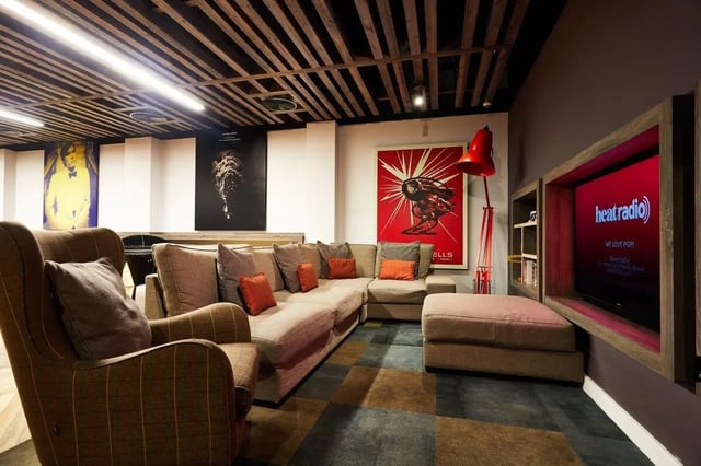 Large sectional sofa patterned armchair red floor lamp television living room at Vita Student Newcastle Westgate in Newcastle Upon Tyne Student Accommodation
