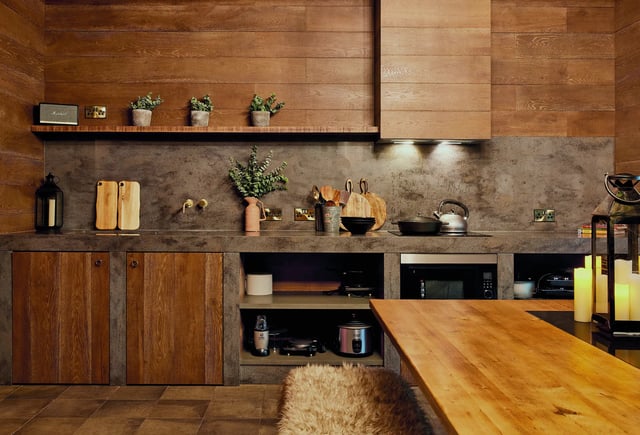 Wooden cabinets concrete countertop microwave kettle and table kitchen at Vita Student Lewisham Exchange in London Student Accommodation