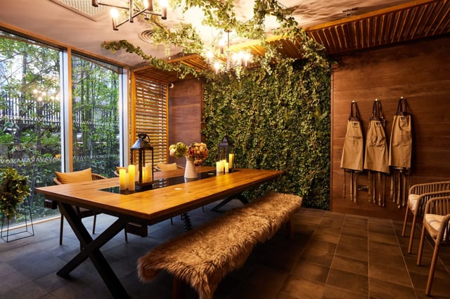 Table bench chairs and plants common area at Vita Student Lewisham Exchange in London Student Accommodation
