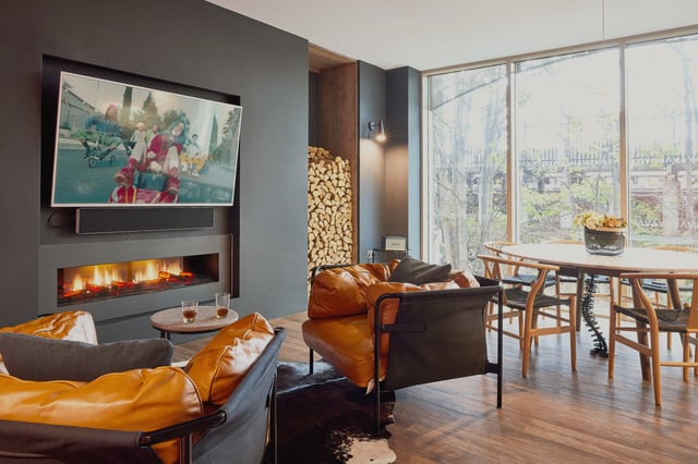 Fireplace TV chairs dining table living room at Vita Student Lewisham Exchange in London Student Accommodation