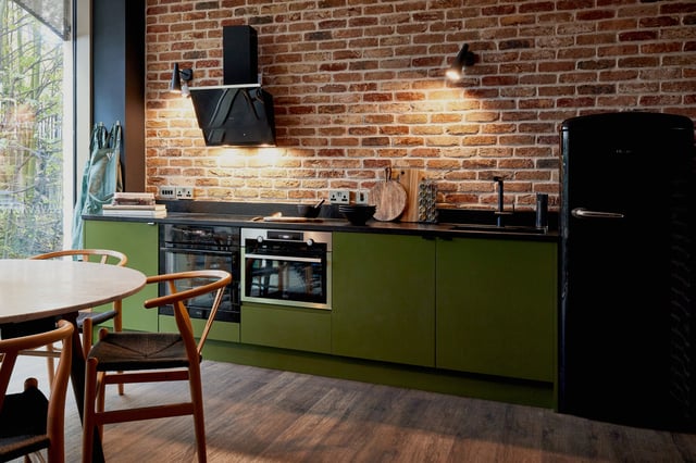 Green cabinets ovens black fridge kitchen. at Vita Student Lewisham Exchange in London Student Accommodation